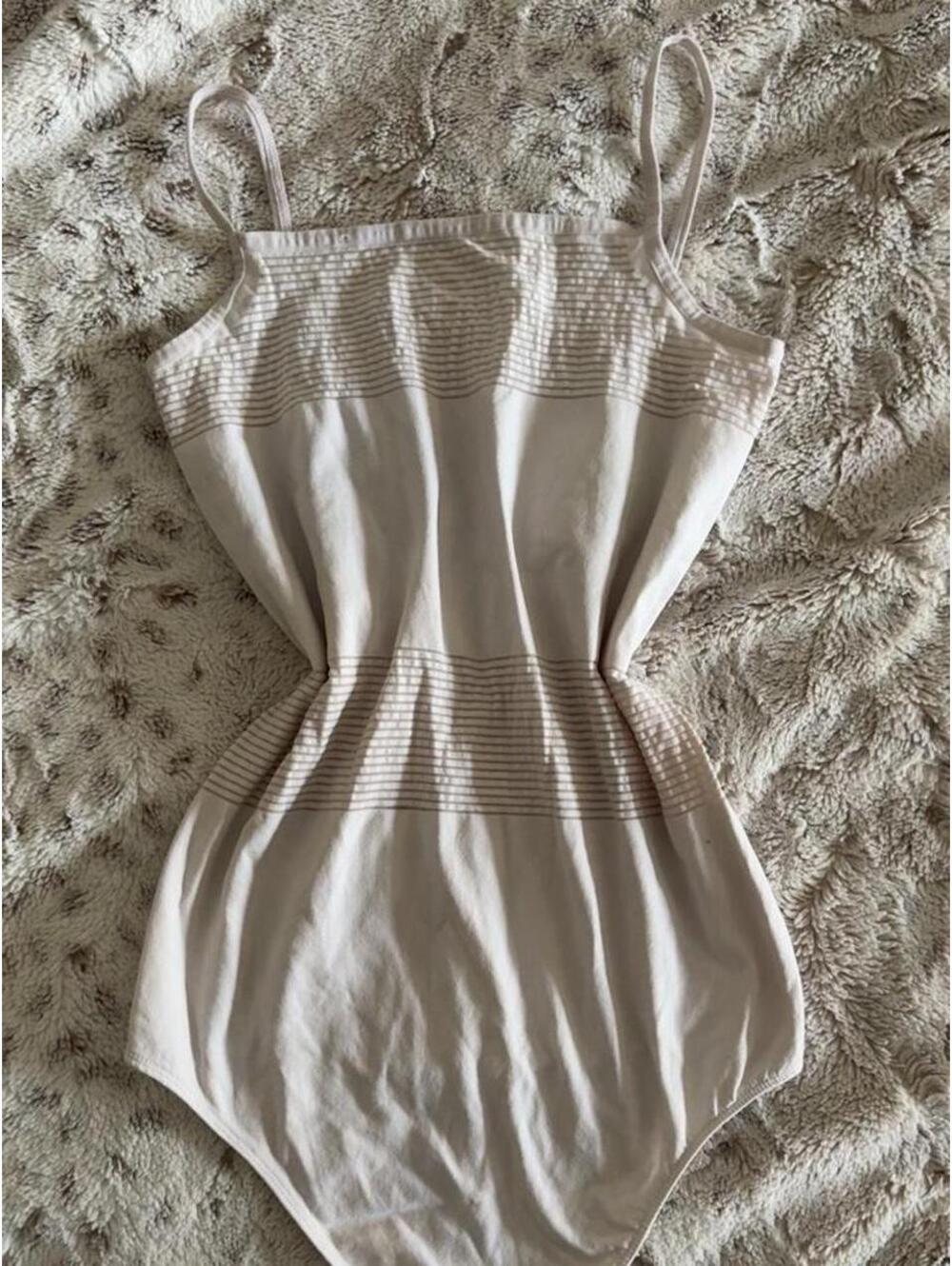 cream white bodysuit with horizontal ribbed stripes on the bust and waist